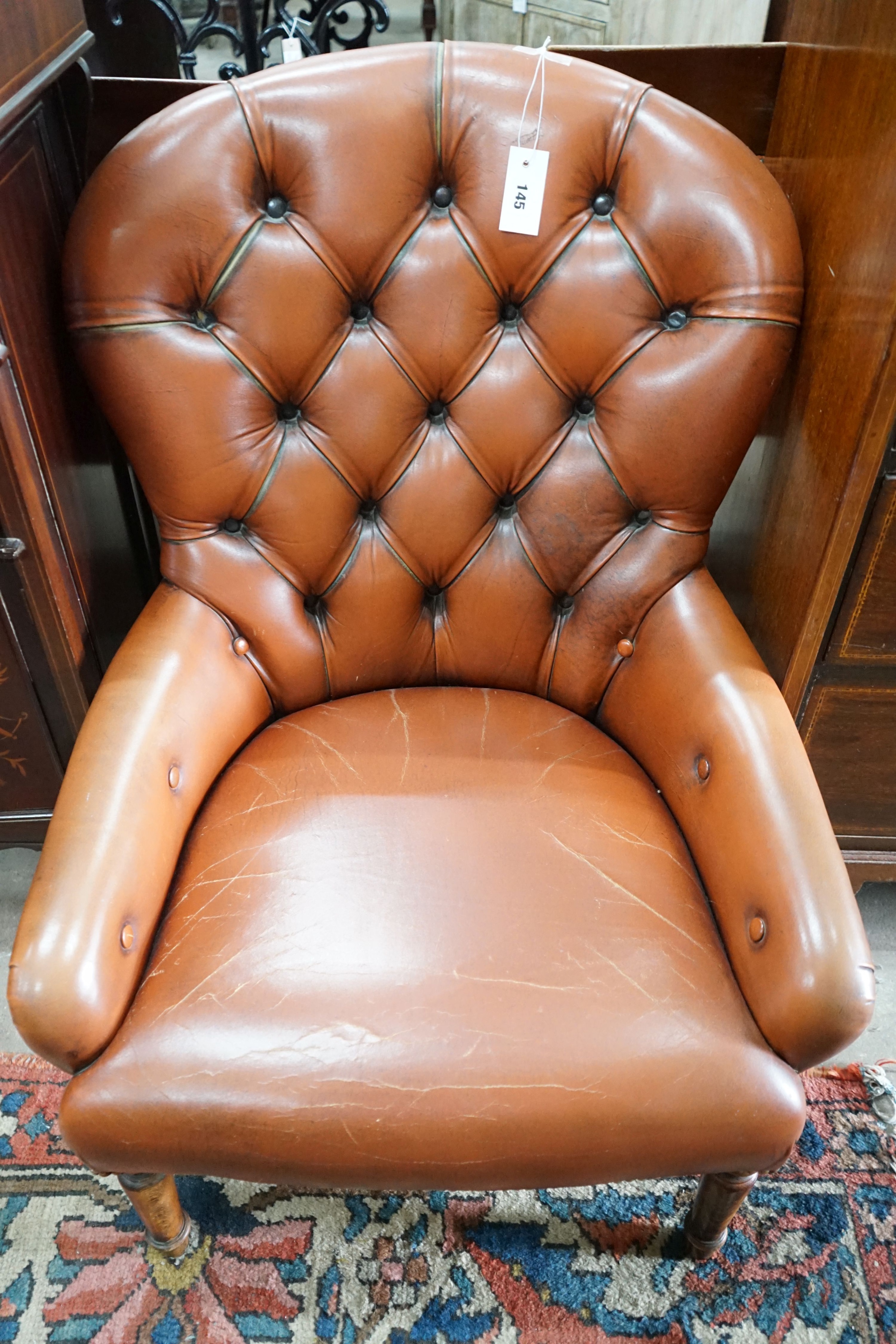 A modern buttoned brown leather easy chair, width 64cm, depth 70cm, height 85cm